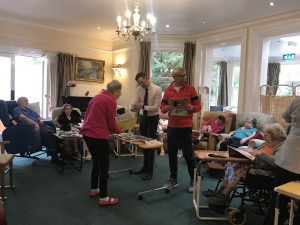 Former Shrewsbury Town players pass round old programmes at Maesbrook Care home during Meadow Memories