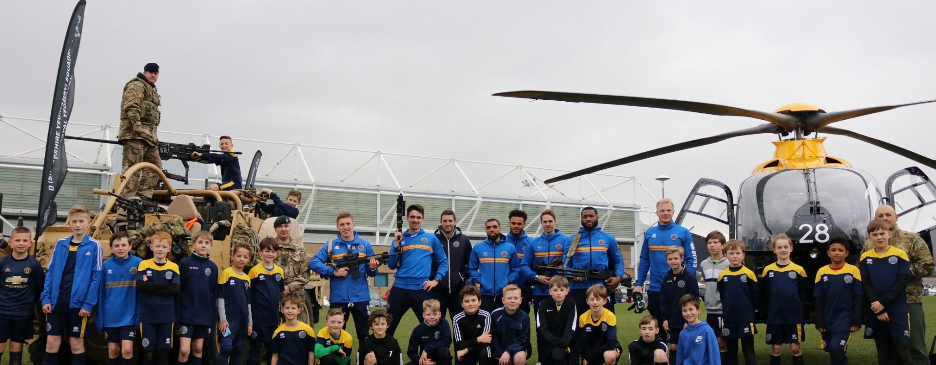Group photo of armed forces, players and ADC squad promoting Community Day